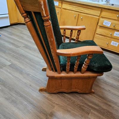 Wooden cane back glider with green cushions - a small table and an antique wooden stool