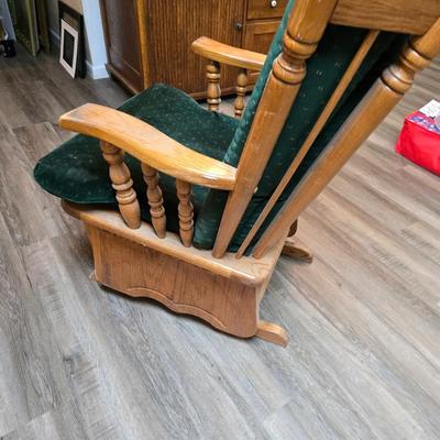 Wooden cane back glider with green cushions - a small table and an antique wooden stool