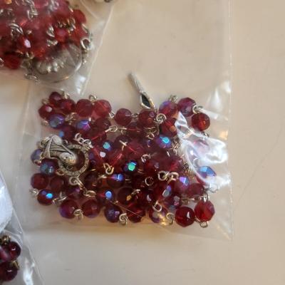 Sale Photo Thumbnail #426: This auction lot is for Five Rosaries with a Pope Case.  Nice collection of various rosaries, one comes with a white holding case, also included is a round, plastic case featuring two Popes.