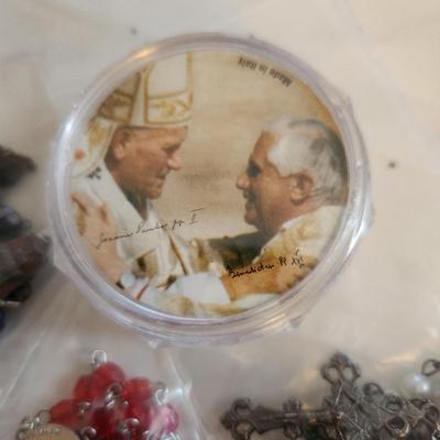 Sale Photo Thumbnail #430: This auction lot is for Five Rosaries with a Pope Case.  Nice collection of various rosaries, one comes with a white holding case, also included is a round, plastic case featuring two Popes.
