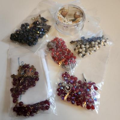 Sale Photo Thumbnail #431: This auction lot is for Five Rosaries with a Pope Case.  Nice collection of various rosaries, one comes with a white holding case, also included is a round, plastic case featuring two Popes.