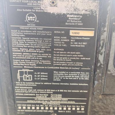 Sale Photo Thumbnail #6: Hearthstone cast iron wood-burning stove featuring decorative soapstone panels. The stove has a viewing window on the front door, a top-loading soapstone panel design, and is freestanding. Designed for efficient heating and aesthetic appeal with intricate