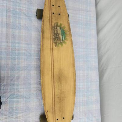 Sale Photo Thumbnail #7: Sector Nine longboard skateboard featuring a wooden deck with a worn graphic design on the underside, painted in green and white with landscape imagery. The board is equipped with trucks and translucent wheels. Some wear is visible on the deck and wheels,