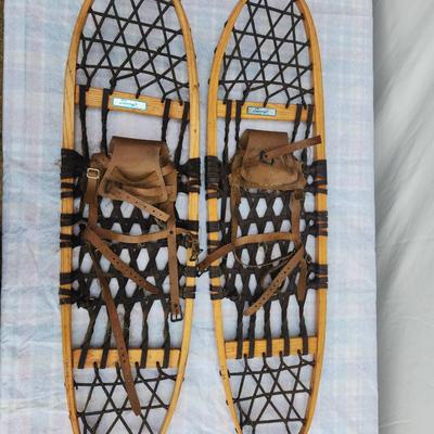 Sale Photo Thumbnail #38: Vintage Sorocraft wooden snowshoes featuring traditional wooden frames and rubberized lacing. Equipped with leather bindings and straps for secure attachment to boots. Made in Canada as indicated on the original labels. Measuring approximately 48 inches i