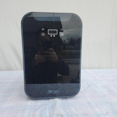 Sale Photo Thumbnail #62: Ergo compact mini electric refrigerator with a sleek black exterior and reflective front panel. Features two internal shelves and a door basket for efficient storage. Suitable for cooling small food items or beverages. Compact design and lightweight struc