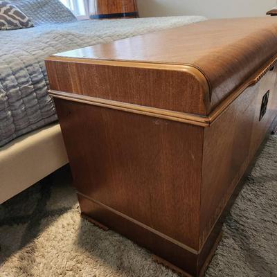 Sale Photo Thumbnail #52: Metal-framed outdoor bench featuring a woven synthetic material for the seat and backrest. Equipped with armrests and curved legs, the bench is designed for durability and outdoor use. The woven pattern provides comfort and adds aesthetic detail. Suitable