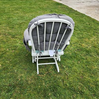 Sale Photo Thumbnail #69: White wooden glider chair and matching ottoman with gray cushioned padding. Features include tufted backrest, padded arms, and a smooth gliding mechanism on both the chair and ottoman. Elegant design suitable for comfort and relaxation.