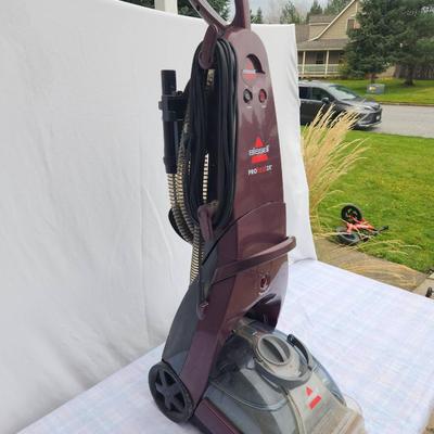 Sale Photo Thumbnail #101: Bissell ProHeat 2X upright carpet cleaner featuring 12 rows of dual DirtLifter power brushes for deep cleaning. Includes a built-in hose and tool storage for accessories. Designed for effective carpet and upholstery cleaning with easy portability. In used