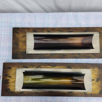 Sale Photo Thumbnail #112: Two rectangular metal wall art sculptures, featuring curved metal accents with gradient coloring effects and mounted on textured gold and brown backgrounds. These pieces showcase a dimensional design with layered metal elements and are intended for wall d