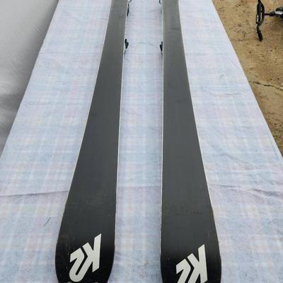 Sale Photo Thumbnail #57: K2 Comanche 2 Com skis with bindings, model measuring 174 cm in length. Features a blue, silver, red, and black design with K2 branding. Included bindings are intact and functional. Bases and edges show normal wear typical for used equipment. Ideal for sk