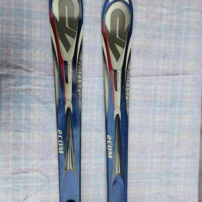 Sale Photo Thumbnail #55: K2 Comanche 2 Com skis with bindings, model measuring 174 cm in length. Features a blue, silver, red, and black design with K2 branding. Included bindings are intact and functional. Bases and edges show normal wear typical for used equipment. Ideal for sk