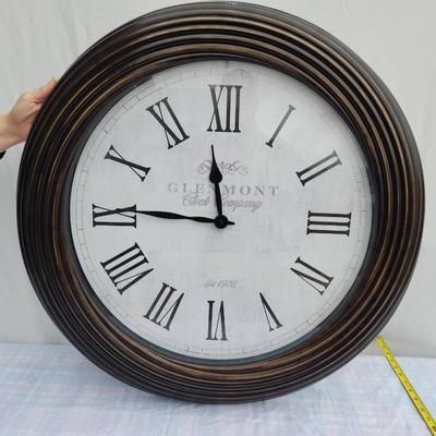 Sale Photo Thumbnail #115: Large round wall clock featuring Roman numeral hour markers and black clock hands on a white face. The clock has a ribbed wooden frame in a dark finish. The face displays the text 'Glasgow, Great George St.' Diameter appears to be around 24 inches, based 