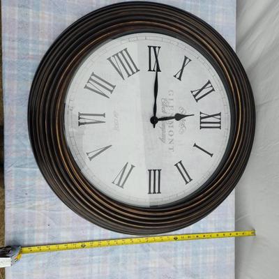 Sale Photo Thumbnail #116: Large round wall clock featuring Roman numeral hour markers and black clock hands on a white face. The clock has a ribbed wooden frame in a dark finish. The face displays the text 'Glasgow, Great George St.' Diameter appears to be around 24 inches, based 