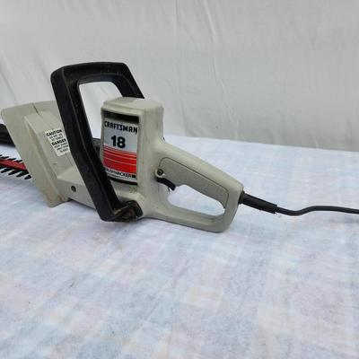 Sale Photo Thumbnail #123: Craftsman 18-inch electric hedge trimmer featuring a durable blade and ergonomic handle. Includes a blade cover for safety. Powered by a standard electrical cord, this trimmer is ideal for light to medium trimming tasks. Condition appears functional with 