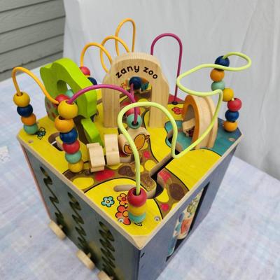 Sale Photo Thumbnail #99: B. Toys Zany Zoo wooden activity cube designed for engaging play. Features bead mazes, spinning alphabet tiles, sliding animal doors, and rotating animal blocks. Made of wood with a multicolor design. Dimensions are not specified. Suitable for toddlers an