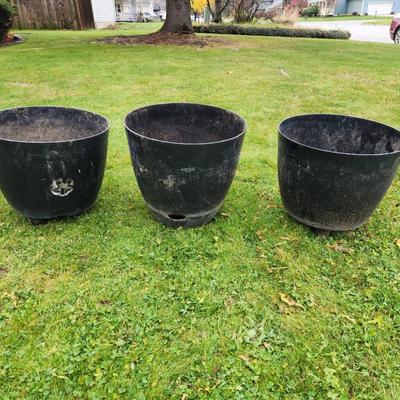 Sale Photo Thumbnail #125: Three large black plastic plant pots featuring built-in drainage holes. Suitable for indoor or outdoor use. The pots show signs of previous use with minor surface wear. Approximate height is displayed in the photo with a tape measure, which indicates over