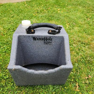 Sale Photo Thumbnail #131: WaterHole EZ-Fill water trough in gray, designed for animals. Constructed from durable, weather-resistant material. Features a sturdy black handle for portability and an integrated white cap for convenient refilling. Suitable for outdoor use in pastures o