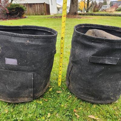 Sale Photo Thumbnail #136: Black fabric garden planter pots designed for growing plants. Each pot has reinforced handles for portability and a breathable material for soil aeration. The approximate height of each pot is visible next to a measuring tape, suggesting they are about 15