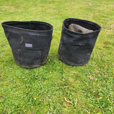 Sale Photo Thumbnail #134: Black fabric garden planter pots designed for growing plants. Each pot has reinforced handles for portability and a breathable material for soil aeration. The approximate height of each pot is visible next to a measuring tape, suggesting they are about 15