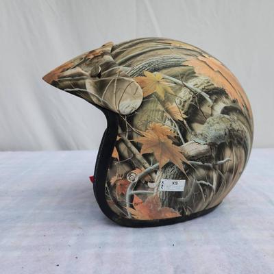 Sale Photo Thumbnail #145: AFX half helmet featuring a camouflage pattern with autumn leaves. Includes an adjustable chin strap with quick-release buckle for secure fitting. Lightweight and designed for safety with padding along the edge. Ideal for outdoor enthusiasts and motorcycl