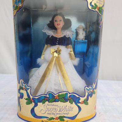 Sale Photo Thumbnail #16: Disney Holiday Princess Snow White doll from the 1997 series, sealed in the original packaging. The doll features Snow White in an elaborate gown with gold and white accents, reflecting a festive holiday theme. The packaging shows some wear but remains in