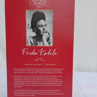 Sale Photo Thumbnail #20: Barbie Inspiring Women Series doll honoring the artist Frida Kahlo (1907-1954). The doll comes dressed in a vibrant outfit inspired by her iconic style, featuring a red blouse, blue skirt, and accessories. It is housed in its original packaging, which inc