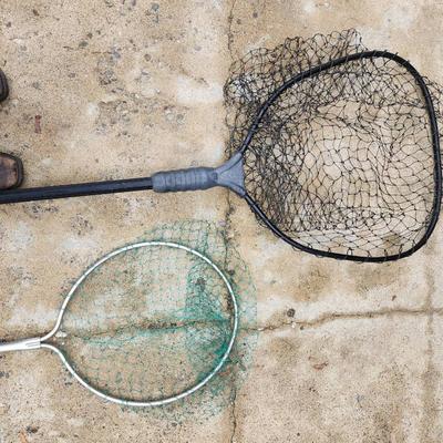 Sale Photo Thumbnail #190: Two fishing nets, featuring one net with a black plastic handle and frame, and another with a metal frame and green netting. Both nets are designed for outdoor use, suitable for fishing or catching small aquatic creatures. Condition shows some wear consis
