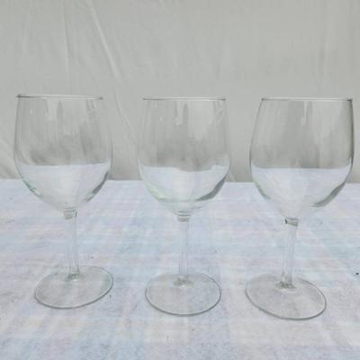 Sale Photo Thumbnail #198: Three clear glass wine goblets featuring a classic design with smooth, rounded bowls and sturdy stems. All pieces are uniform in size and shape, crafted for wine service or display. Condition is good with no visible chips or cracks. Suitable for everyday 