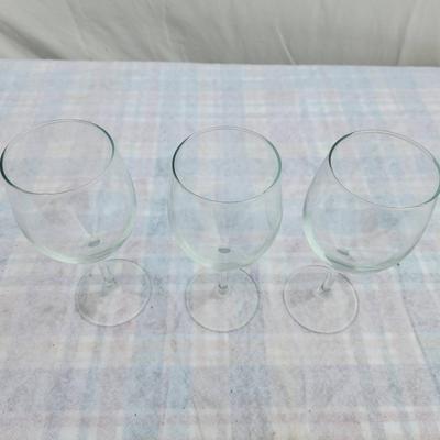 Sale Photo Thumbnail #199: Three clear glass wine goblets featuring a classic design with smooth, rounded bowls and sturdy stems. All pieces are uniform in size and shape, crafted for wine service or display. Condition is good with no visible chips or cracks. Suitable for everyday 