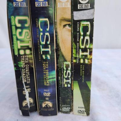 Sale Photo Thumbnail #203: CSI: Crime Scene Investigation DVD box set including Seasons 3, 4, 5, and 7. Each box set contains multiple discs for the complete seasons. Cases show some wear, suggesting prior use, but the content inside remains intact. Produced by CBS Home Entertainme