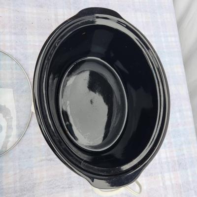 Sale Photo Thumbnail #208: General Electric (GE) slow cooker featuring an apple design with black-and-white checkered trim. Includes a removable ceramic inner pot, glass lid with handle, and a dial for settings (off, warm, low, and high). Appears intact with visible use. Suitable f