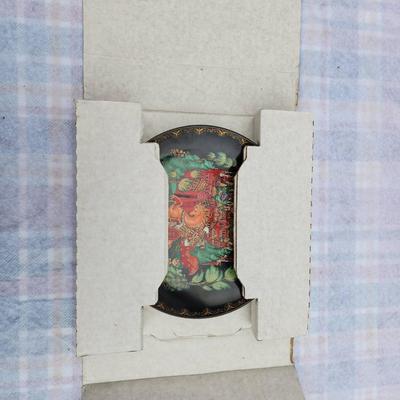 Sale Photo Thumbnail #216: Russian hand-painted lacquerware plate featuring a vibrant fairy tale scene with a horse and castle motif. The reverse side includes inscriptions in Cyrillic detailing the plate's origins and theme. Accompanied by documentation, illustrations, and origina