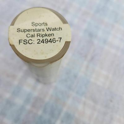 Sale Photo Thumbnail #232: Cal Ripken themed Sports Superstars watch, featuring a leather strap and a unique dial design. Comes in its original packaging, which showcases related artwork and details. The item appears to be labeled FSC: 24946-7, and it highlights the baseball supers