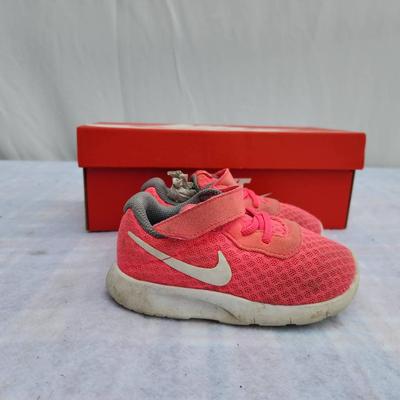 Sale Photo Thumbnail #87: Nike Tanjun toddler shoes in pink with white accents, featuring a breathable mesh upper, velcro strap closure, and cushioned sole for comfort. Includes original red Nike box. Size 7C, as specified on the box. Shoes show slight wear on the soles but remain