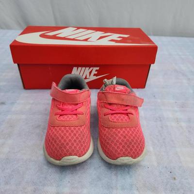 Sale Photo Thumbnail #86: Nike Tanjun toddler shoes in pink with white accents, featuring a breathable mesh upper, velcro strap closure, and cushioned sole for comfort. Includes original red Nike box. Size 7C, as specified on the box. Shoes show slight wear on the soles but remain