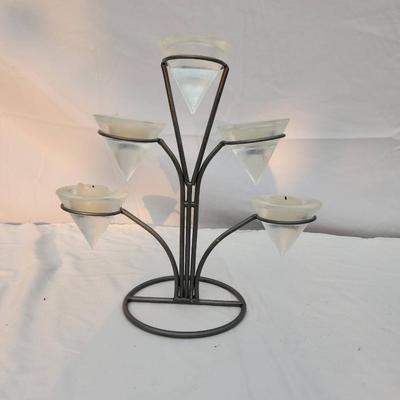 Sale Photo Thumbnail #248: Metal candle holder featuring five frosted glass votive cups arranged in a tiered design. The sturdy metal frame has a circular base and branched arms holding each votive. Includes a measurement scale in the image for size reference. Condition shows minor