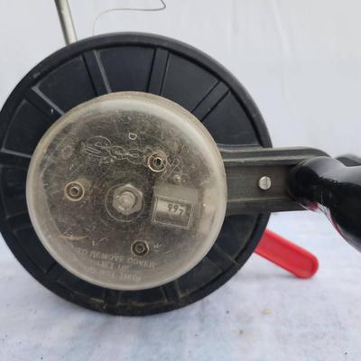 Sale Photo Thumbnail #257: A Walker Downrigger with adjustable mounting base and a secondary downrigger reel. The Walker Downrigger features a manual crank and depth dial. Both items are made primarily of metal and plastic. Some wear is visible, consistent with prior use, but the i