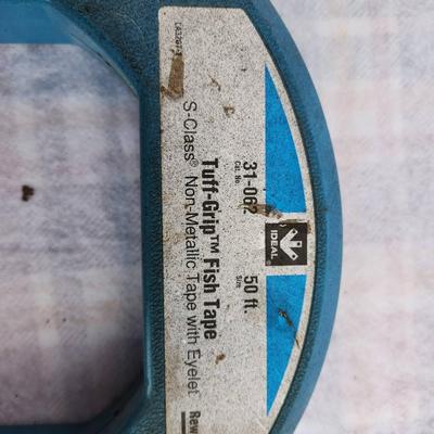 Sale Photo Thumbnail #270: One Ideal 50 ft Tuff-Grip fish tape made of S-Class non-metallic material with a steel core, featuring a durable blue housing and ergonomic hand grip. Additionally, the lot contains one 3-blade metal propeller, approximately 6 inches in diameter, suitable