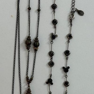 Sale Photo Thumbnail #602: Brassy 28" necklace with diamond-shaped open lattice pendant, and a Disney Mickey Mouse icon 15" necklace with a black and gold finish.