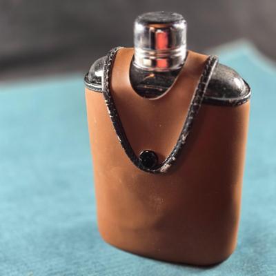 Sale Photo Thumbnail #483: This auction lot is for a Vintage Flask with Faux Leather Case. This is a useful and handsome Flask with Faux Leather Case.  The flask itself is glass and marked TRC.  The case shows wear on the black edging.  Overall in good condition.
