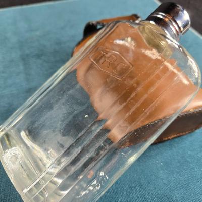 Sale Photo Thumbnail #486: This auction lot is for a Vintage Flask with Faux Leather Case. This is a useful and handsome Flask with Faux Leather Case.  The flask itself is glass and marked TRC.  The case shows wear on the black edging.  Overall in good condition.
