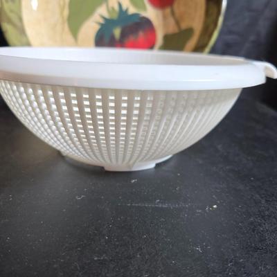 Two large serving bowls a glass cake pan, strainer and 5 square glass containers with cork stoppers