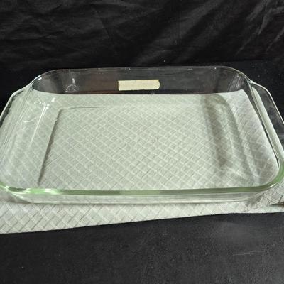 Two large serving bowls a glass cake pan, strainer and 5 square glass containers with cork stoppers