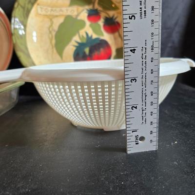 Two large serving bowls a glass cake pan, strainer and 5 square glass containers with cork stoppers