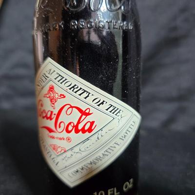 Working 1970s Coca-Cola wall clock with a faux wood grain plastic frame and a commemorative Coca-Cola bottle from the 1984 Summer...