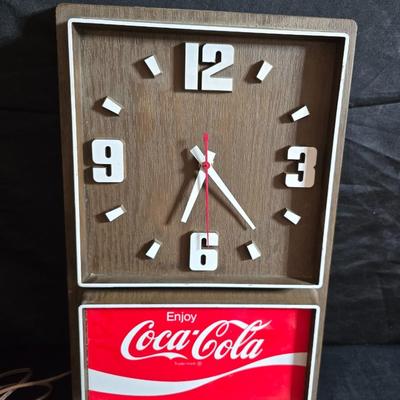 Working 1970s Coca-Cola wall clock with a faux wood grain plastic frame and a commemorative Coca-Cola bottle from the 1984 Summer...