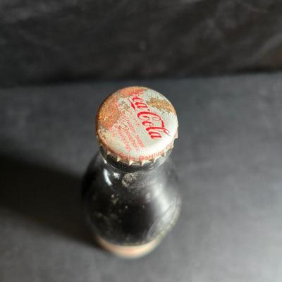 Working 1970s Coca-Cola wall clock with a faux wood grain plastic frame and a commemorative Coca-Cola bottle from the 1984 Summer...
