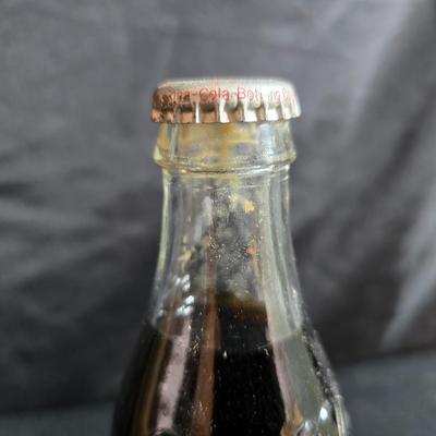 Working 1970s Coca-Cola wall clock with a faux wood grain plastic frame and a commemorative Coca-Cola bottle from the 1984 Summer...
