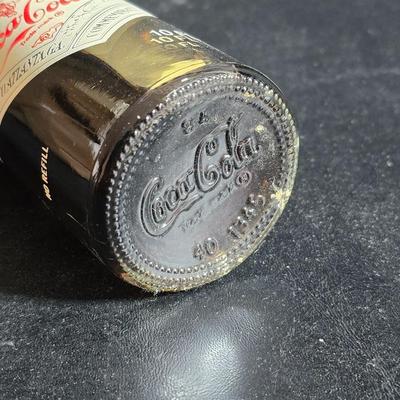 Working 1970s Coca-Cola wall clock with a faux wood grain plastic frame and a commemorative Coca-Cola bottle from the 1984 Summer...