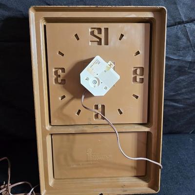 Working 1970s Coca-Cola wall clock with a faux wood grain plastic frame and a commemorative Coca-Cola bottle from the 1984 Summer...